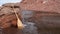 wooden canoe paddle on a rocky lake shore with floating ice abd blowing wind