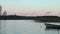 A wooden canoe parked at the edge of a lake