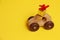 Wooden car toy and golden gift box with red ribbon on roof car on corrugated yellow background, present delivery for fathers day