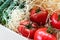 Wooden and cardboard crate box with fresh ripe tasty red tomatoes and green cucumbers with wood shavings filler