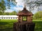 Wooden carved birdhouse on a tree stump, a feeder for birds