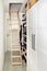 Wooden ceiling pull down attic folding stairs in small minimalist hallway corridor.