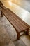 Wooden chair or wood bench inside a building along a walkway.