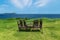 Wooden chairs on grass meadow with view on ocean and Udo Island, Jeju Island, South Korea