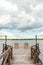 Wooden chairs on pier with streetlights near tranquil lake