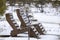 Wooden chairs in the snow by a frozen lake