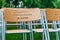 Wooden chairs stand outside in the park in the rain. Empty auditorium, green grass, waterdrops, closeup