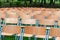 Wooden chairs stand outside in the park in the rain. Empty auditorium, green grass, waterdrops, closeup