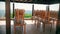 Wooden chairs standing on tables in cafe with summer veranda panoramic view