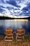 Wooden chairs at sunset on lake shore