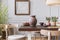 Wooden chairs at table with vase and flowers in grey dining room interior with poster. Real photo