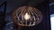 wooden chandelier with a light bulb hangs in the evening in cafe