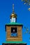 Wooden chapel with a bell in the window and a Golden dome with a cross