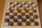 Wooden checkerboard with checkers spaced on table