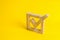 A wooden checkmark in the box on a yellow background. The concept of suffrage, voting in elections. Election of the President or G