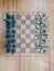 A wooden chess board with metal figurines top view