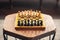 Wooden chess pieces on a board game, on a wooden polygonal vintage table, selective focus