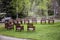 Wooden chiars witting on grass circle with yellow wildflowers  for group activity with ATV parked on drive and woods with aspens