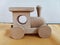 Wooden children`s toy locomotive is standing on yellow mats against the background of wall
