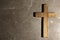Wooden Christian cross on brown table, top view with space for text. Religion concept
