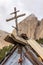 Wooden Christian cross on roof of tourist hut as symbol of protection on rocky mountain peak background at countryside. Caucasus,