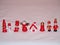 Wooden Christmas figurines of red and white color standing in a row, stick figures and winter motifs, holiday decorations