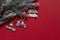 Wooden Christmas and new year toys on Christmas tree branches on the high corner on red background,