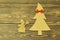 Wooden Christmas tree decorated with red bow tie and cheerful vintage snowman with broom on old wooden dark background