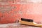Wooden cleaning brush against red ragged wall