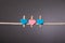 Wooden clips with pink and blue heart on the white rope on grey background