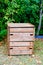 Wooden closed home garden compost bin of organic material composter in back house outdoor