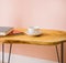 Wooden coffee table. There is a cup and saucer on the table and books. Modern interior