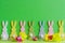 Wooden colorful rabbits with country frlowes on green bacground for ester holiday