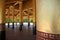 Wooden columns of gold and red within a traditional Burmese Palace building in Mandalay