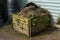 Wooden compost bin full of rotting vegetation garden waste
