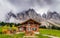 Wooden cottage overlooking the impressive Dolomites rock formation in northern Italy