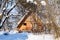 Wooden cottage in snow-covered garden in winter