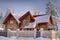 Wooden cottage of stained timber, snowy woods in winter.