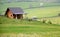 Wooden country cottage in the middle of meadows in springtime