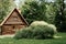 Wooden country house from a log in the forest on a sunny summer day. Exterior one storey cottage, bungalow.