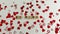 Wooden craft letters that spell Be Mine with red heart confetti on a white background