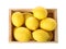 Wooden crate full of fresh lemons on white background