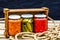 Wooden crate with glass jars with variety of canned vegetables isolated