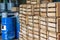 Wooden crates with finished products in stock. Blue metal barrels on the background