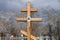 Wooden cross on a background of spring trees on the Troitsk cemetery of the Krasnoyarsk city. Russia.