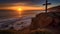 Wooden cross on a cliff overlooking the ocean at sunset. Christian resurrection symbol.