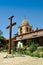 Wooden cross in front of Mission belltower