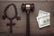 Wooden cross gavel and money on brown table