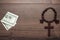 Wooden cross and money on brown table background