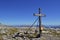 Wooden cross on a mountain top with stones and grass Berchtesgadens Alps
